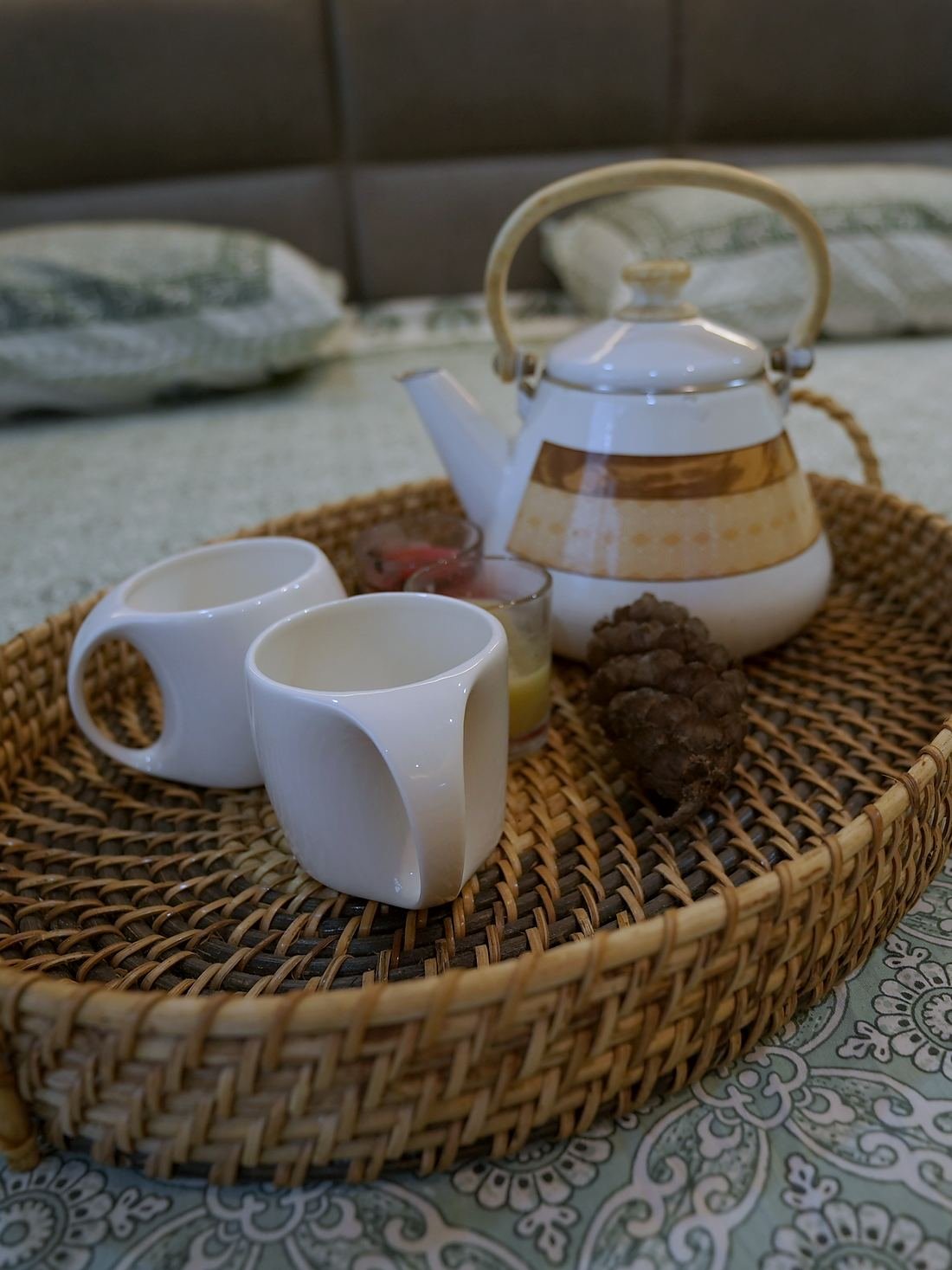 A cane tray of morning tea set out on a block-printed bedspread