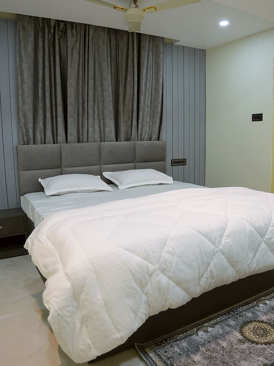 Deluxe Room head-on, curtains drawn back from the window