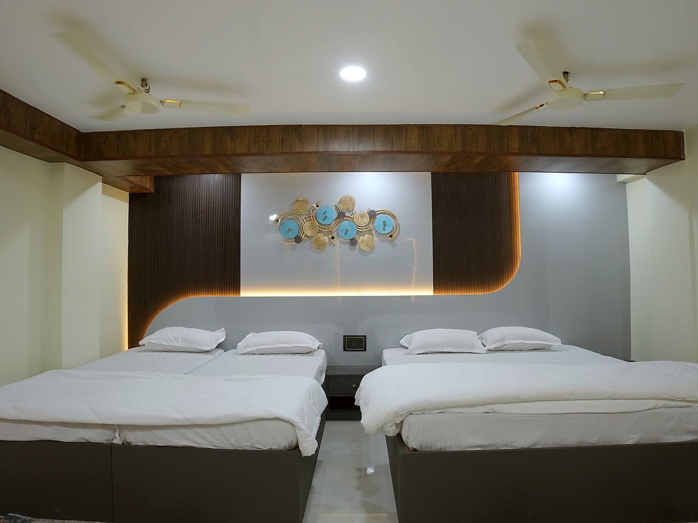 Grand Suite — two large beds under a curved, cove-lit feature wall