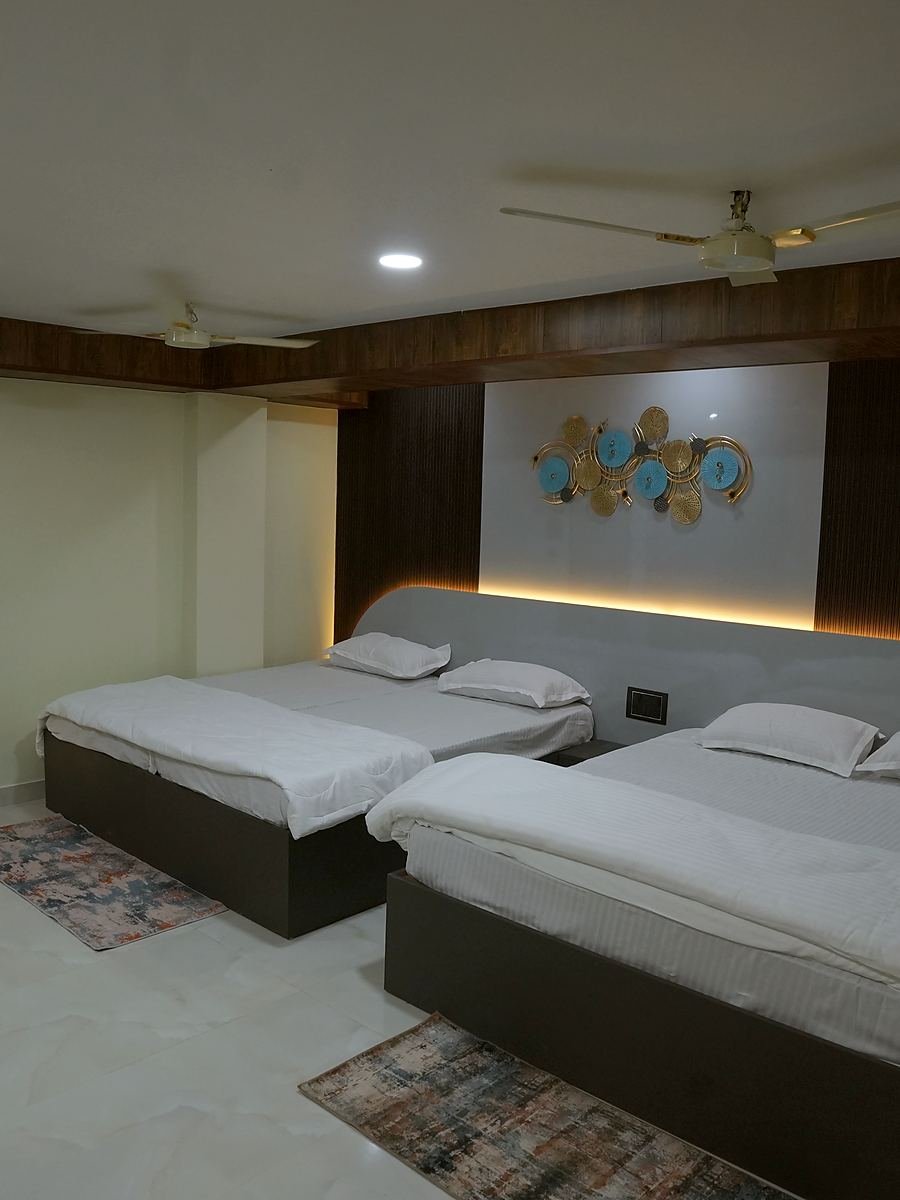 Grand Suite beds beside the sculptural metal wall piece